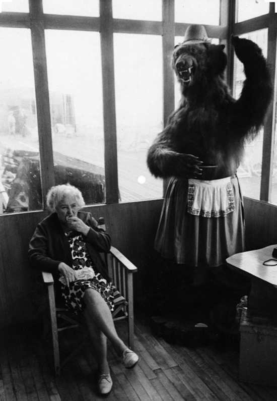 Ray-jones-Elderly-woman-eating-pie-seated-in-a-piershelter-next-to-a-stuffed-bear-1969.